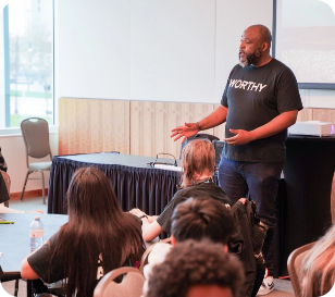 particpant in pink hat wearing ribbons alongside supporter in yellow shirt