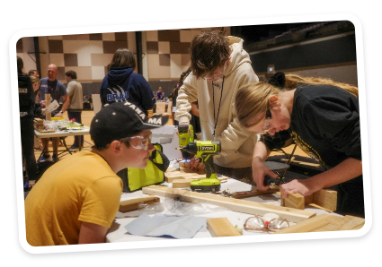 Students in shop working with tools and safety goggles on