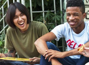 Two teens sitting and smiling.