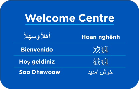 Welcome Centre sign displaying "Welcome" in multiple languages, including Arabic, Vietnamese, Spanish, Chinese, Turkish, and Dari.