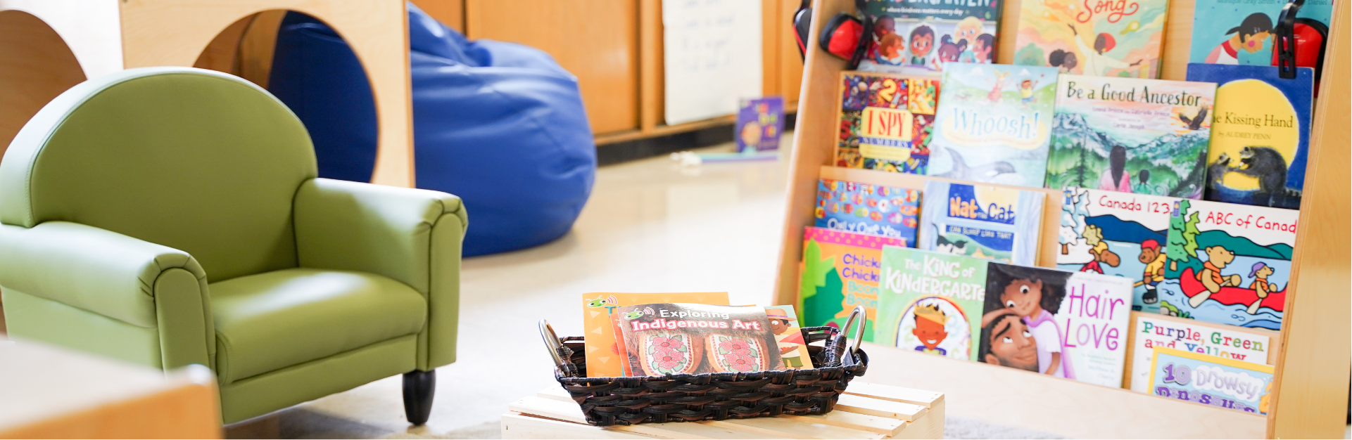 Classroom reading corner featuring a display of children's books and a child-sized chair.