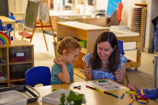 Kindergarten students reading with an educator